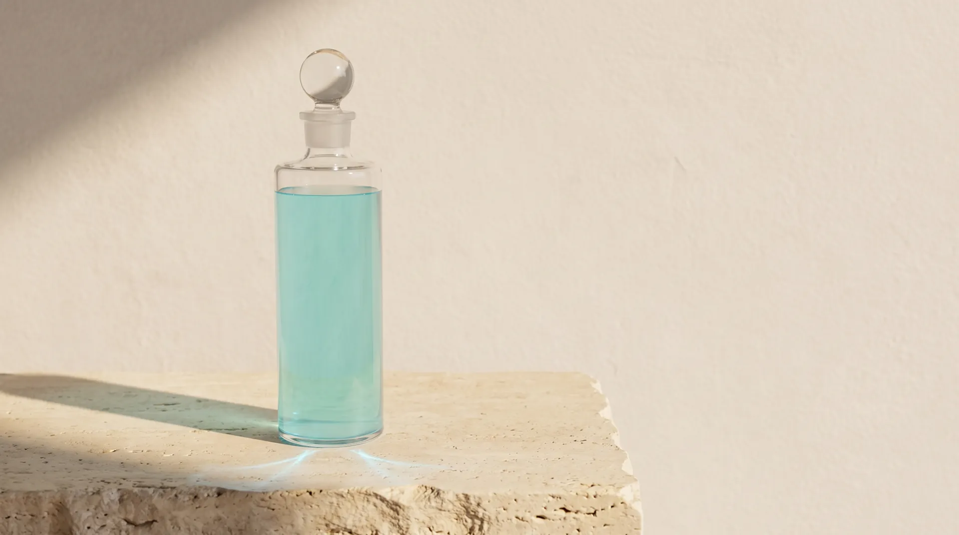 The bottle on a travertine block against a pale plaster wall in morning sun