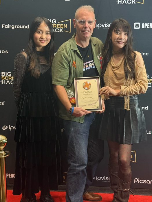 Three guests with a certificate on the red carpet