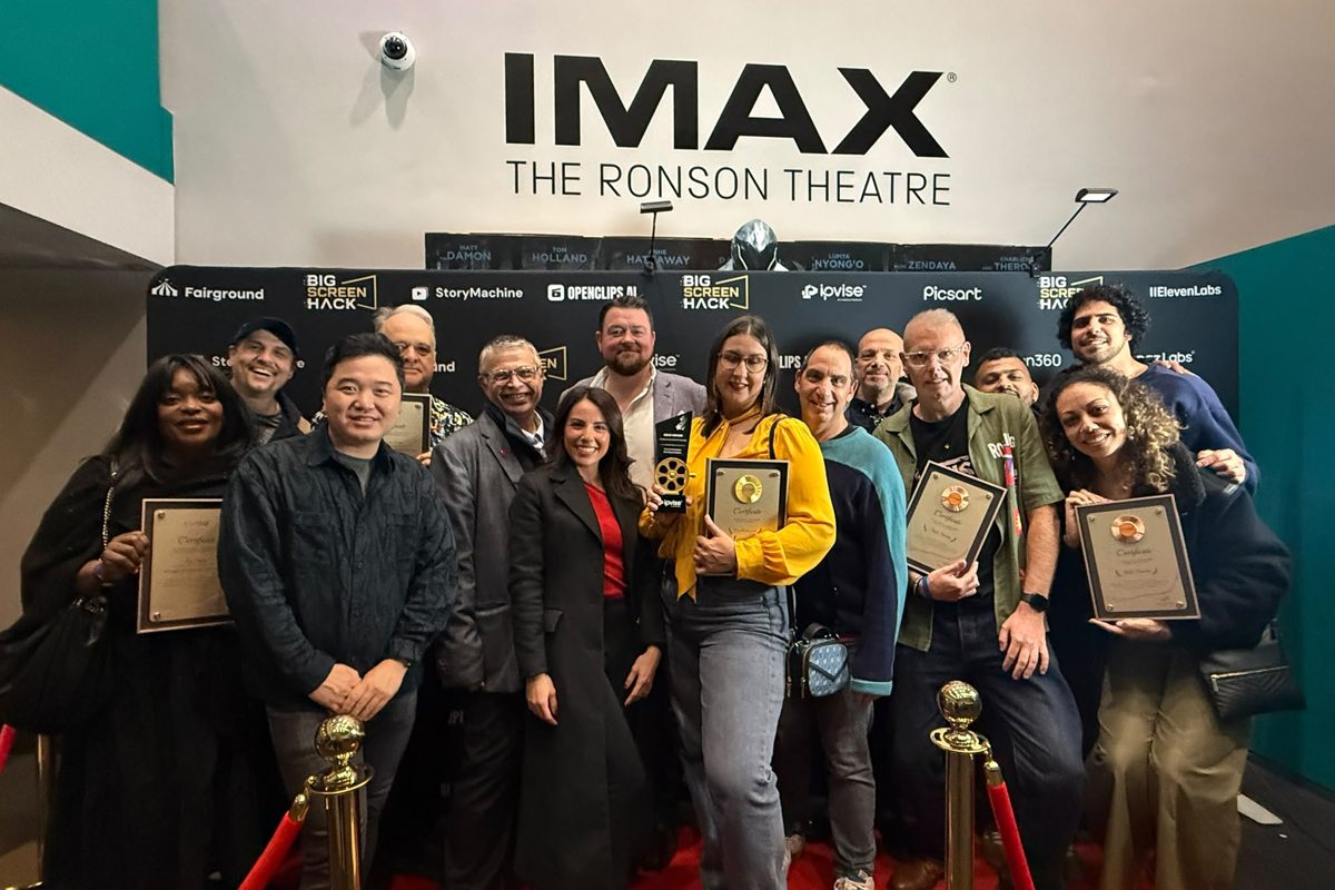 Some of our filmmakers and winners with their awards under the IMAX sign